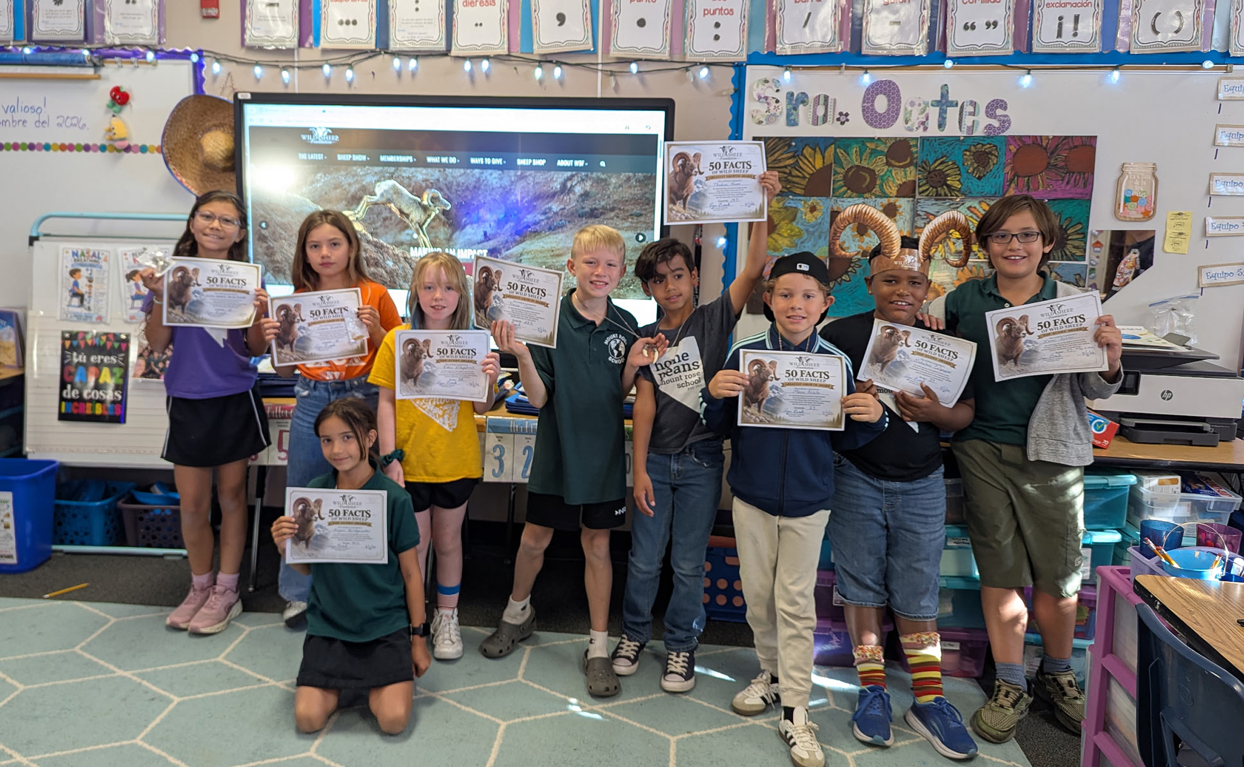Students holding their 50 Facts for 40 Years challenge certificate